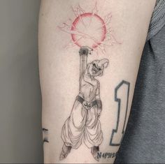 a person with a tattoo on their arm holding a ball and throwing it up in the air