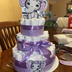 a purple and white diaper cake with an elephant on top