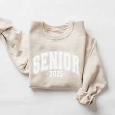 Senior 2025 Shirt, Class of 2025, College Senior, High School Senior, 2025 Graduate T-Shirt, Graduate Crew tees, Retro Vintage Senior shirt ABOUT: :) This pre-shrunk, classic fit sweatshirt is made with air-jet spun yarn for a soft feel and reduced pilling. :) Pre-shrunk :) Classic fit with no center crease :) 1x1 athletic rib knit collar with spandex :) Air-jet spun yarn with a soft feel and reduced pilling :) Double-needle stitched collar, shoulders, armholes, cuffs, and hem: 50% preshrunk cot Sr 2023 Shirts, White Varsity Tops With Name Print, Collegiate Crew Neck Top With Name Print, Senior Class Shirts Design, Senior Sweatshirts Ideas, Senior Clothes, 2025 Graduate, Senior Things, Senior Class Shirts