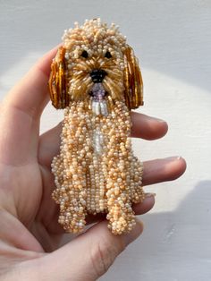 a small dog made out of beads in someone's hand