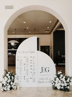 a large white sign sitting in the middle of a room next to flowers and candles