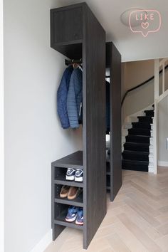 an open closet in the corner of a room with shoes and coats hanging on it