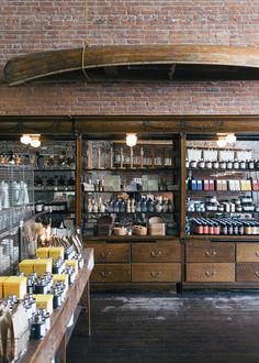 the inside of a coffee shop with shelves full of items and jars on display in front of them