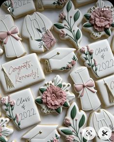 decorated cookies are arranged on a table for a graduation party, including flowers and gowns