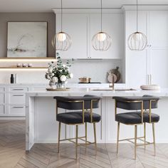 a kitchen with two bar stools next to an island in the middle of it