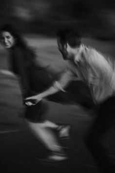 black and white photograph of two people riding skateboards