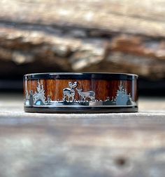 a wooden ring with deer and trees on it