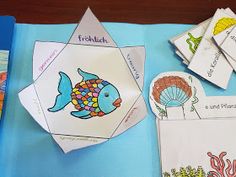 children's books and crafts are displayed on a blue tablecloth with an ocean theme