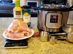 a plate with raw chicken on it next to an instant pot