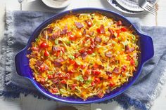 a blue casserole dish filled with pasta and sausage