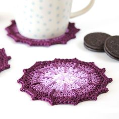 crocheted coasters and cookies on a table with a coffee cup in the background