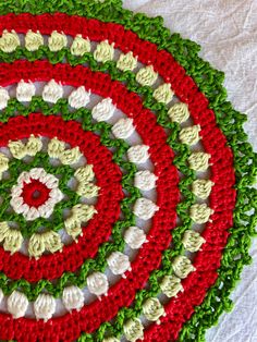 a crocheted rug with red, white and green circles on it's sides