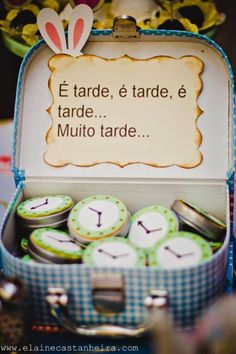 an open suitcase filled with lots of small clocks next to a sign that says e tarde, trade, e mulito tarde