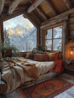 a bed sitting under a window next to a wooden floor covered in pillows and blankets