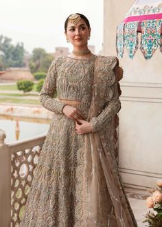 a woman in a bridal outfit standing on a balcony with her hands on her hips