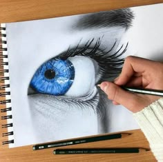 someone is drawing an eye with colored pencils