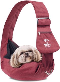 a small dog is sitting in a red sling bag with its head resting on it's back