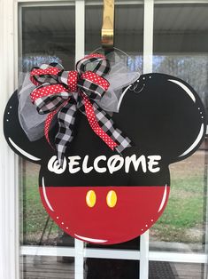 a mickey mouse door hanger that says welcome with a red and black bow on it