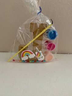 a plastic bag filled with crafting supplies on top of a white counter next to a wall