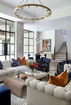 a living room filled with lots of furniture next to a stair case in front of a window