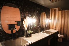 a bathroom with two sinks and a large mirror on the wall next to each other