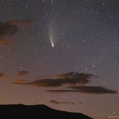 the night sky is filled with stars and clouds, as well as an object in the distance