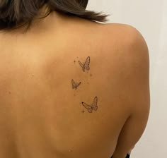 the back of a woman's shoulder with three butterflies on it