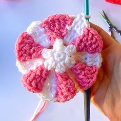 a crocheted flower being worked on by someone