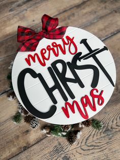 a merry christmas ornament hanging on a wooden table