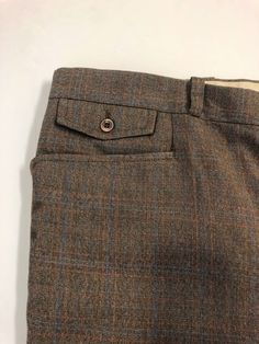 "Vintage Men's 80's Brown, Plaid, Straight Leg, Pants (W40) 1097 These Men's Pants come in a brown polyester/viscose blend and has a plaid print in blue and orange with a zipper fly, five pockets, and straight leg fit with a pressed seam. The pants are heavy weight and do not stretch and are not lined. 65% Polyester 35% Viscose *These pants are in like new condition. *If shipped within the US, they will go Priority Mail for a quick delivery! Size: (W40 x L32) Waist: 40\" Hips: 44\" Inseam: 33\" Brown Straight Pants With Hip Pockets, Brown Trousers With Hip Pockets, Classic Plaid Bottoms With Pockets, Classic Brown Bottoms For Fall, Tailored Brown Bottoms With Tapered Leg, Brown Tailored Tapered Leg Bottoms, Plaid Business Casual Pants With Pockets, Tailored Brown Bottoms With Belt Loops, Plaid Pants With Pockets For Business Casual