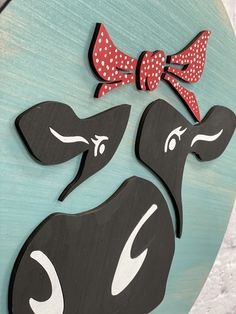 two wooden cut outs with bows on them