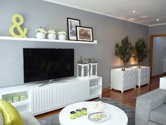 a living room filled with furniture and a flat screen tv on top of a white entertainment center