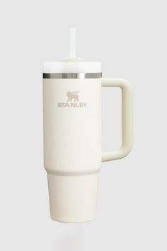 a white coffee cup with a straw sticking out of it's side and the word stanley on top