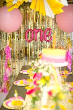 the table is set up with pink and yellow decorations