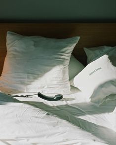 a phone laying on top of a bed next to pillows