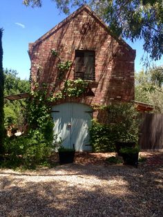 an old brick building with ivy growing on it's door and windows, surrounded by trees