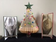 an origami christmas tree next to two folded books