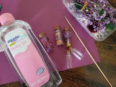 an empty bottle sitting on top of a table next to some flowers and other items