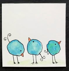 three blue birds are standing in a row on a white card with black edges and one bird has orange beaks