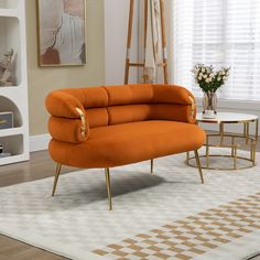 an orange couch sitting on top of a white rug