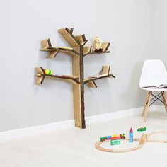 a child's room with toys on the floor and a tree made out of cardboard