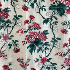 red flowers and green leaves are on a white striped background with vertical horizontal stripes in the center