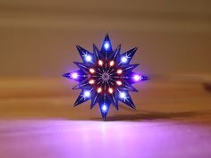 a blue and red star shaped decoration sitting on top of a wooden table