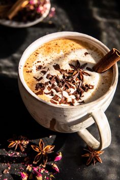 a cup of coffee with cinnamon and star anise on top