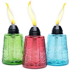 three colorful glass candles with yellow and red flamers in them on a white background