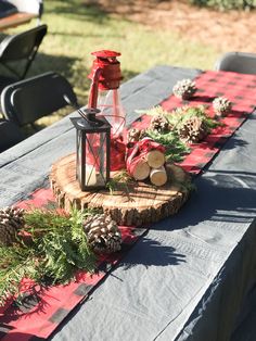 a table topped with a lantern and pine cones