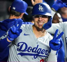 a dodgers baseball player giving the peace sign