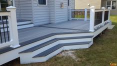 a deck with steps and railings in front of a house