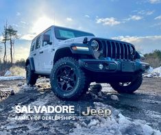 a white jeep parked on top of snow covered ground