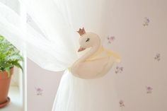 there is a stuffed swan on the curtain